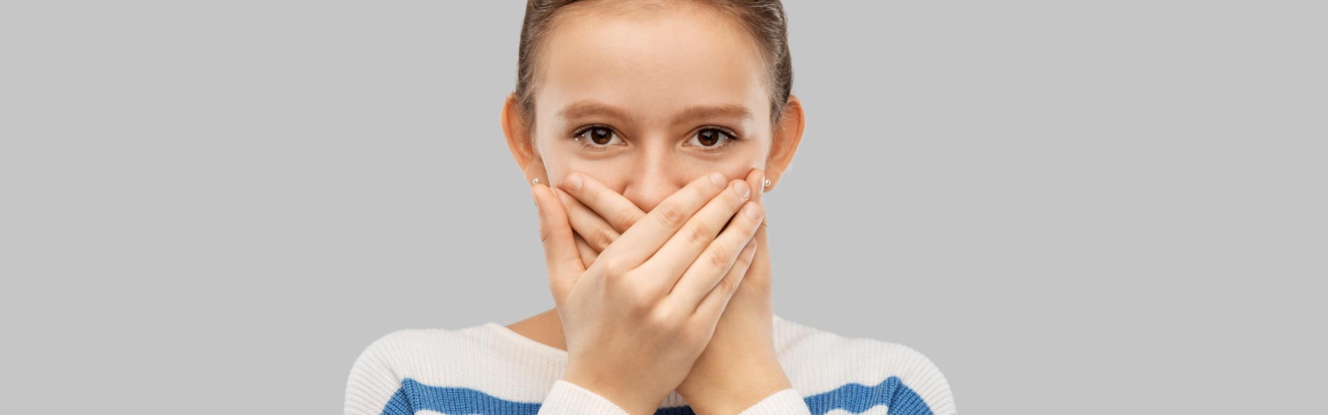 A girl closing her mouth with hands